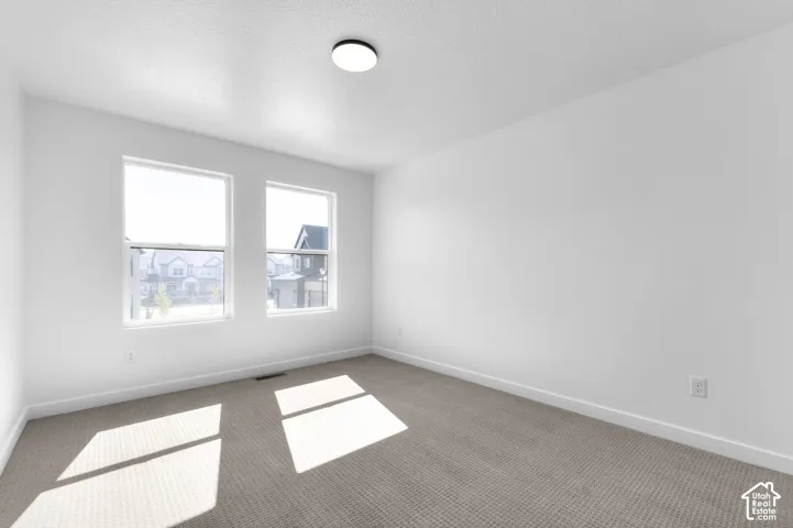 Neutral-toned carpeting, dual pane windows, and a flush-mount ceiling light fixture