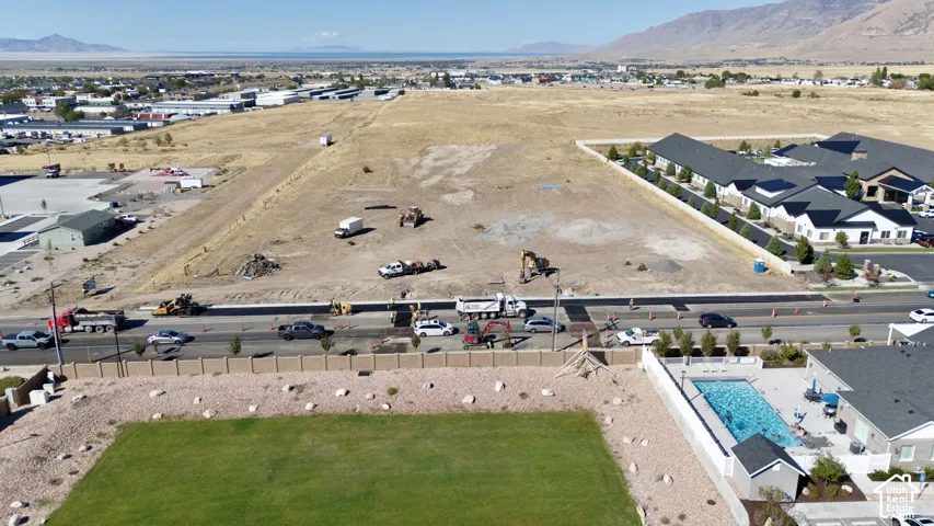 Expansive land parcel with graded terrain, bordered by paved roadways and existing structures