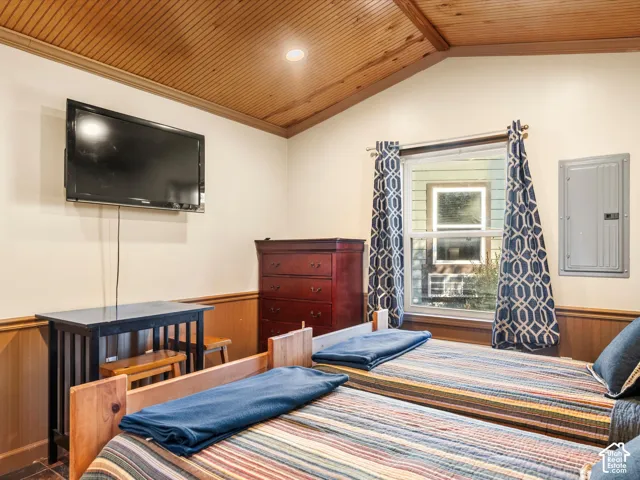 Vaulted ceilings with natural wood-plank finish, wainscoting, and recessed lighting