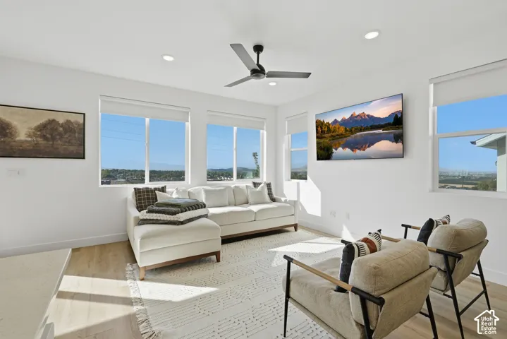 Light-filled interior featuring expansive windows, recessed lighting, wood-finish flooring, and a sleek ceiling fan