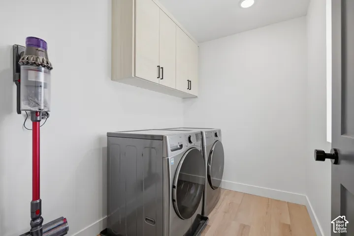 Utility room featuring wall-mounted upper cabinetry with matte black hardware, recessed ceiling lighting, and wood-finish flooring