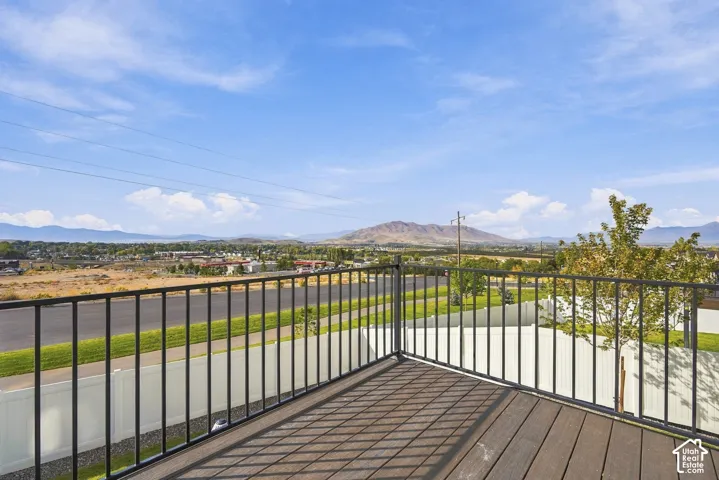 Elevated deck featuring composite wood-finish decking and black metal railing, overlooking mountain and valley scenery