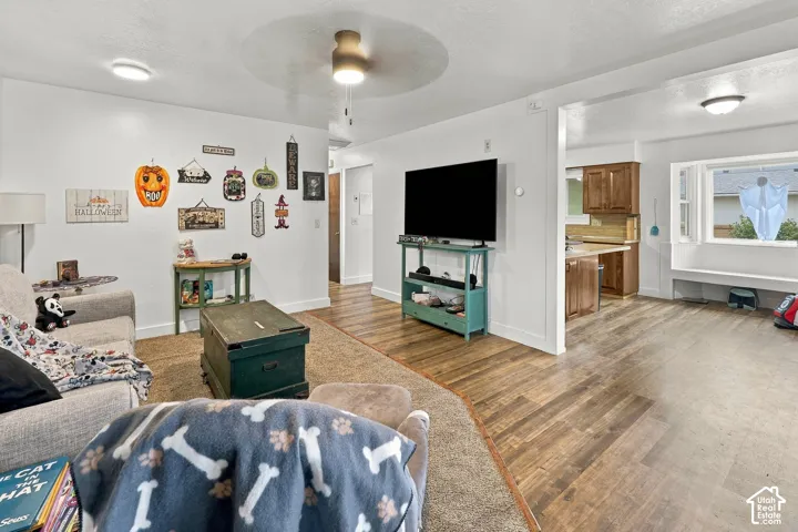 Open-concept interior featuring wood-finish flooring, recessed lighting, a ceiling fan, and a built-in window seat