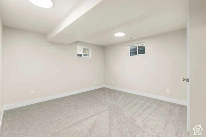 Recessed lighting, light-toned carpeting, two windows, and neutral wall paint
