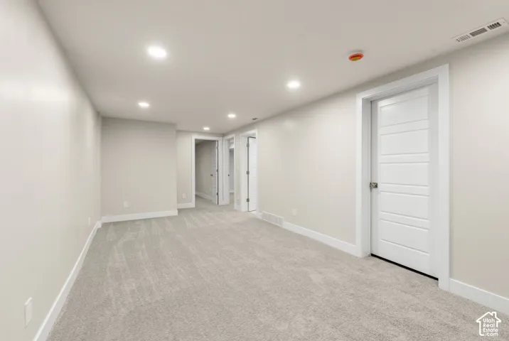 Recessed ceiling lighting, light gray carpet flooring, white interior doors, and neutral wall paint