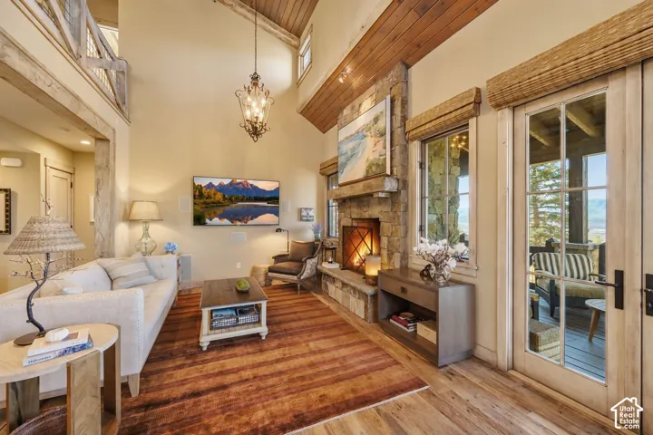 Soaring vaulted ceilings with exposed wood beams create an open, light-filled great room anchored by a stacked-stone fireplace with built-in hearth seating