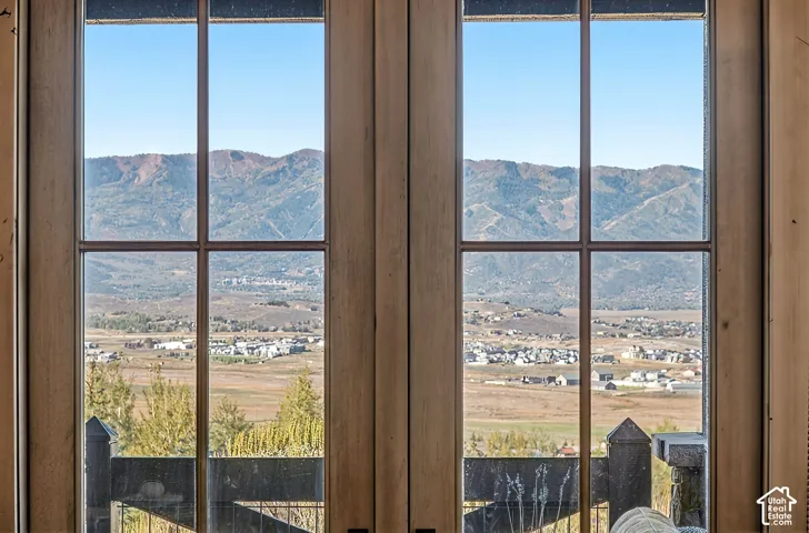 Multi-pane windows with wood-finished frames showcasing a mountain and valley landscape