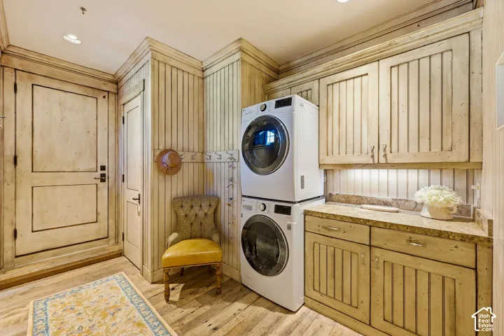 Custom millwork featuring floor-to-ceiling vertical plank paneling, built-in cabinetry with stone-finish countertops, and wood-finish flooring