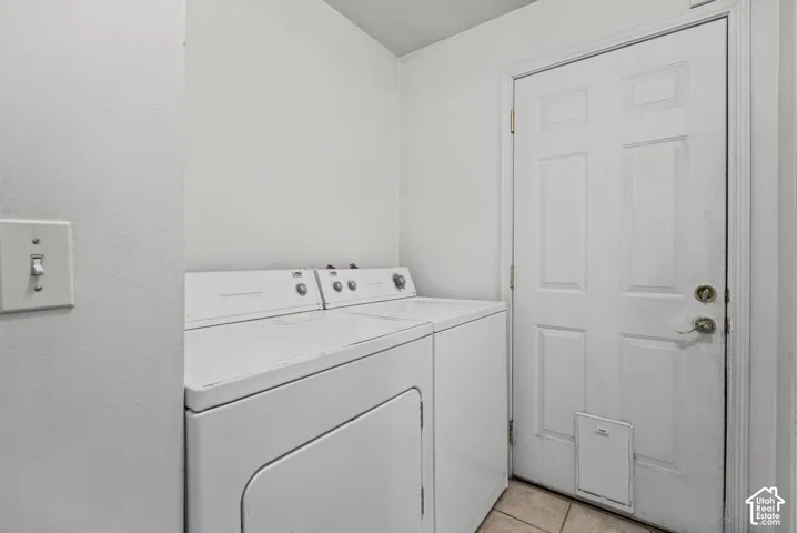Laundry room area featuring tile flooring and a six-panel exterior door with integrated pet access