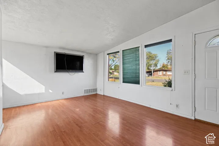 Interior space featuring wood-finish flooring, white walls, and large windows providing abundant natural light