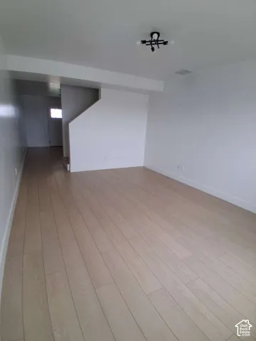 Interior space featuring wood-finish flooring, neutral walls, and a modern multi-bulb ceiling fixture