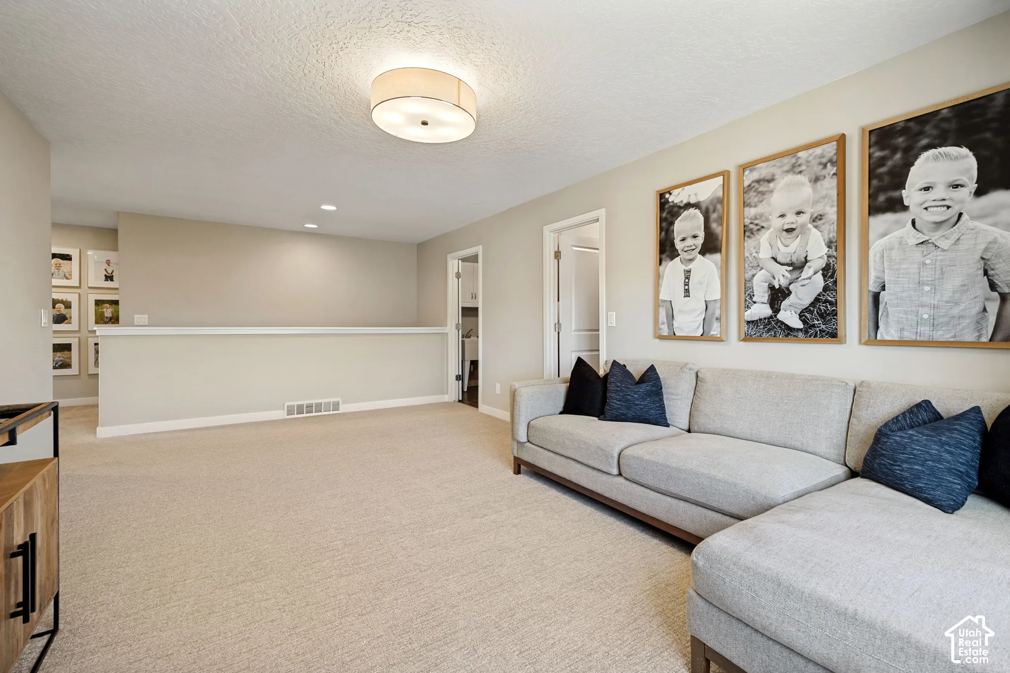 Neutral-toned wall paint, neutral carpeting, recessed ceiling lighting, and a drum-style flush-mount fixture