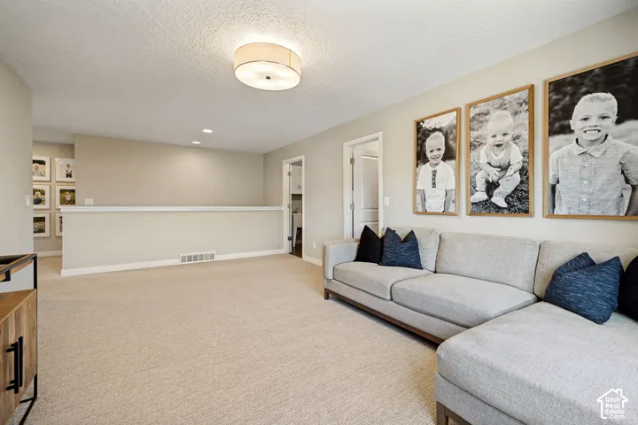 Neutral-toned wall paint, neutral carpeting, recessed ceiling lighting, and a drum-style flush-mount fixture