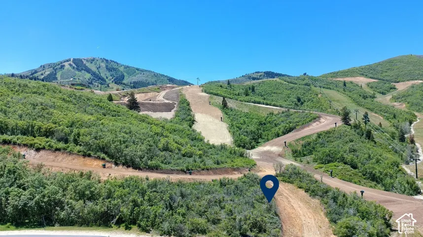 Expansive mountain terrain featuring rugged natural topography, dense vegetation, and established access trails