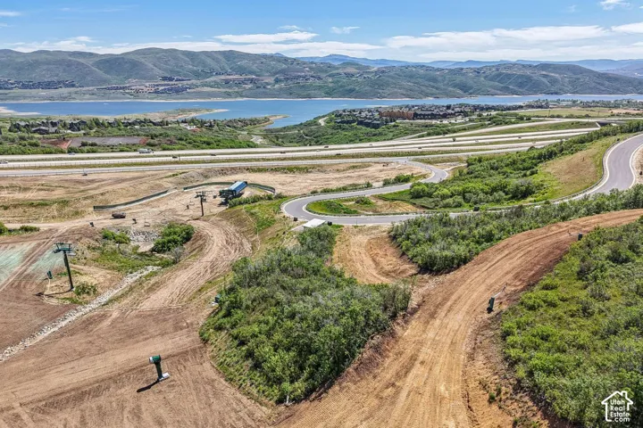 Elevated lot featuring mountain terrain, natural vegetation, and water frontage