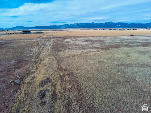 Expansive acreage featuring wire fencing and prominent mountain range horizon