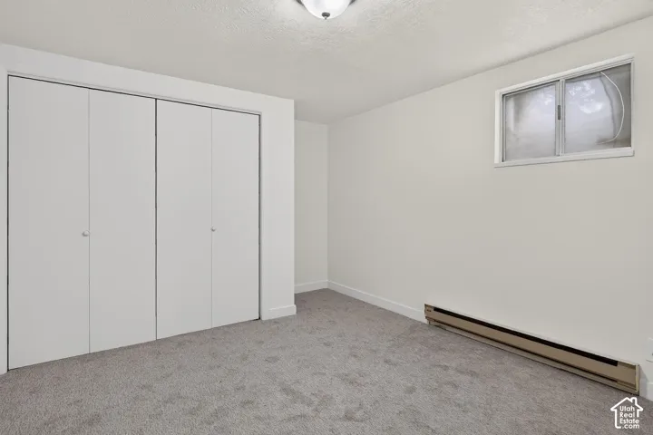 Neutral interior featuring wall-to-wall carpeting, high-gloss closet doors, and a rectangular window