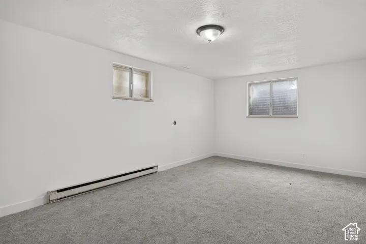 Neutral interior room featuring wall-to-wall carpeting, white walls, flush-mount lighting, and dual slider windows