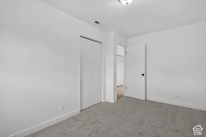 Neutral-toned wall-to-wall carpeting, bi-fold closet doors, flush-mount ceiling lighting, and solid-core interior doors