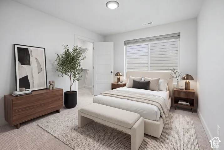 Neutral-toned carpeted flooring, window with horizontal blinds, four-panel interior door, and walk-in closet featuring wire shelving