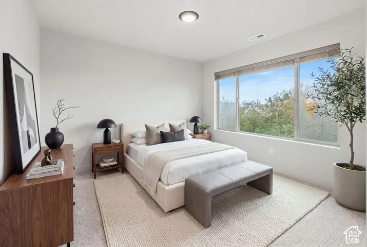 Neutral-toned interior featuring wall-to-wall carpeting, large picture window with integrated blinds, and flush-mount ceiling lighting