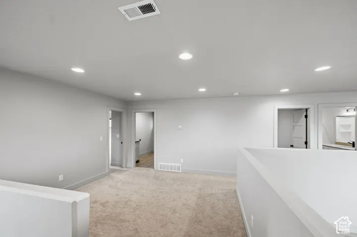 Open-concept interior space featuring neutral wall paint, recessed lighting, and wall-to-wall carpeting