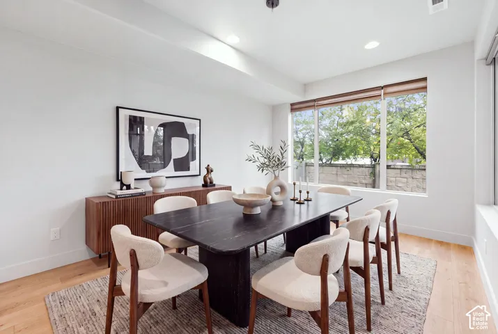 Neutral wall palette featuring wood-finish flooring, recessed lighting, and large windows with integrated roller shades