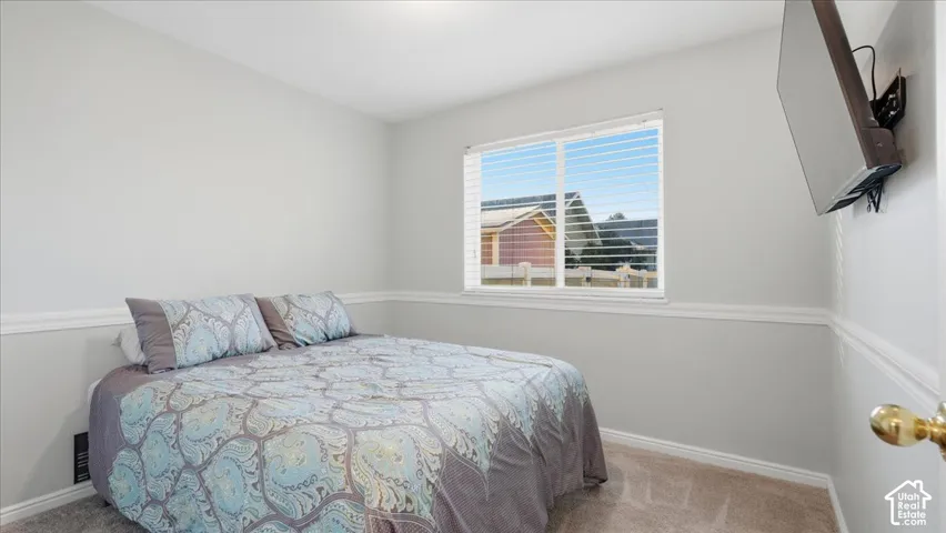 Neutral wall paint, white chair rail molding, wall-to-wall carpeting, and a dual-pane horizontal sliding window