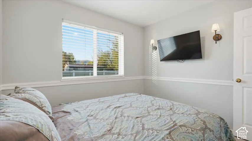 Room featuring a window with horizontal blinds, chair rail molding, and wall-mounted light fixtures
