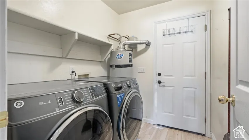 Laundry area featuring built-in shelving, wood-finish flooring, and a solid-core entry door