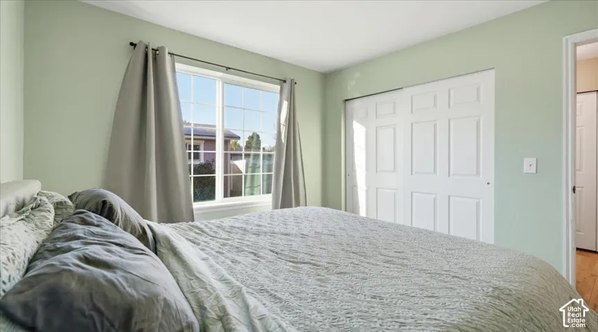 Room featuring neutral-toned walls, a large multi-pane window, and a white paneled sliding closet door