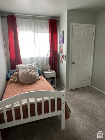 Neutral-toned room featuring plush wall-to-wall carpeting and a single-panel interior door with brushed nickel hardware