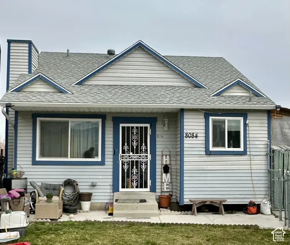 Exterior featuring horizontal lap siding, a gabled roofline with multiple dormers, an external chimney, and a decorative metal security screen door