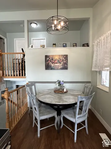 Open-concept interior featuring wood-finish flooring, a decorative metal orb pendant light, and an interior wall cutout