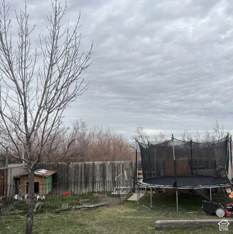 Backyard space featuring a tall wood privacy fence and metal perimeter fencing