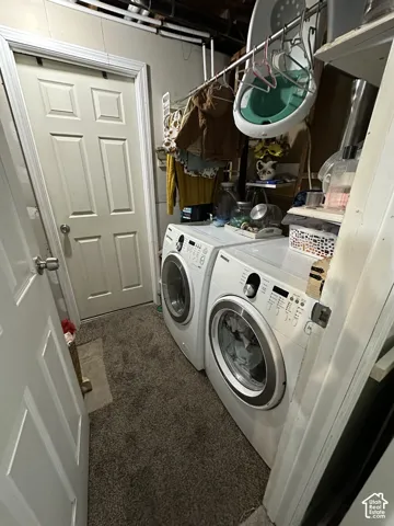 Utility room featuring high-capacity front-load laundry appliances, overhead metal hanging rod, built-in shelving, and a six-panel interior door