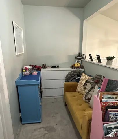 Neutral-toned interior space featuring a recessed wall niche, carpeting, and a half-wall partition