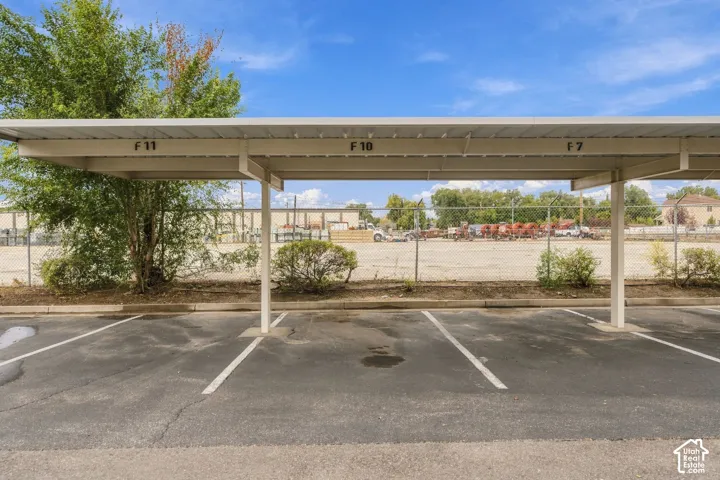 Covered parking structure featuring numbered stalls and asphalt surface
