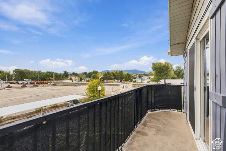 Covered balcony featuring concrete flooring and black metal railing