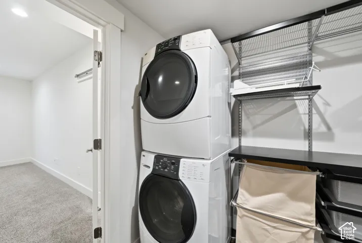 Stacked front-load laundry appliances with integrated wire shelving and a built-in folding surface