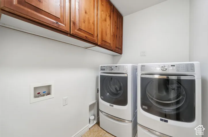 Laundry room featuring wood-finish cabinetry, white wall-mounted appliance hookups, and a recessed plumbing access panel