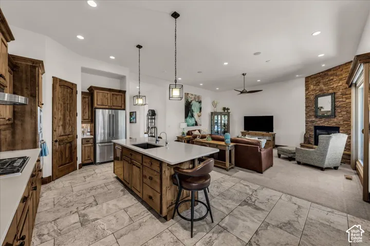Open-concept living space featuring a kitchen island with seating, stainless steel appliances, and wood-finish cabinetry