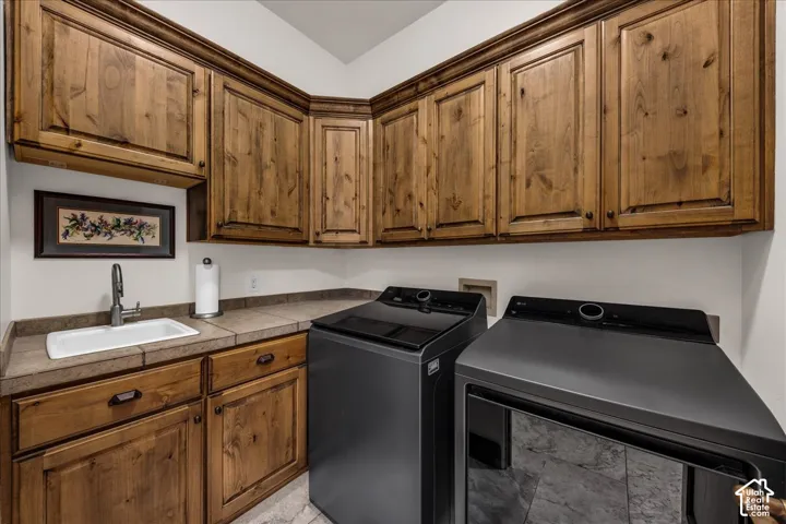Wood cabinetry, built-in sink, and tile countertops