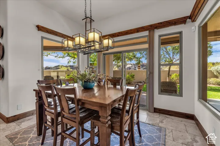 Tray ceiling with exposed wood beams, tile flooring, and a multi-paneled sliding glass door