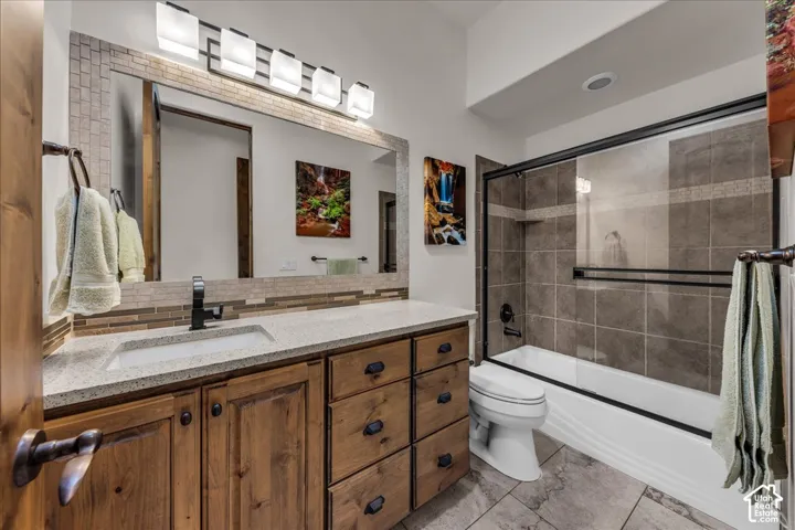 Vanity with integrated sink, stone-finish countertop, and wood cabinetry