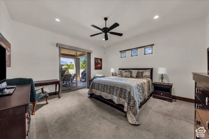 Recessed lighting, ceiling fan, sliding glass door to exterior patio, three high transom windows, and neutral carpeting