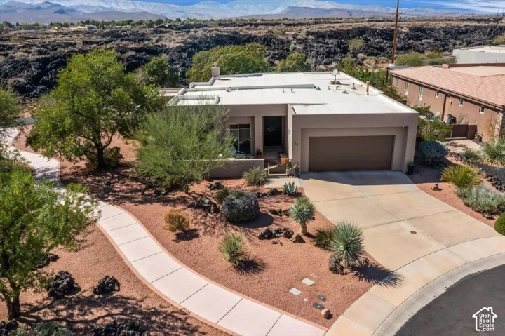 Contemporary desert home with an attached two-car garage, concrete driveway, and a concrete pathway