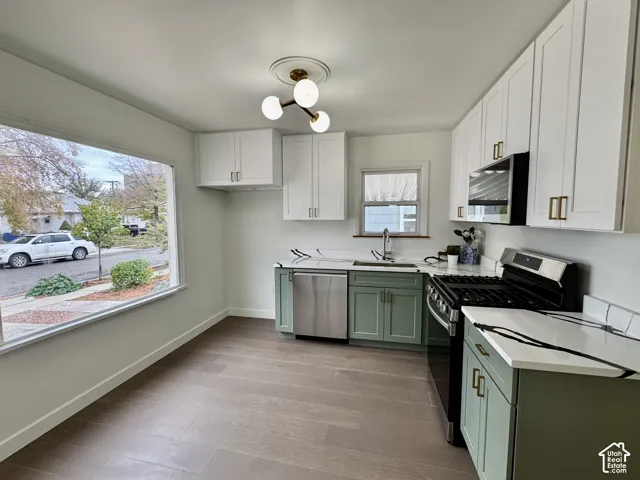 Newly remodeled kitchen with new soft close cabinetry, real wood floors and stunning quartz countertops. Huge window and deep kitchen sink