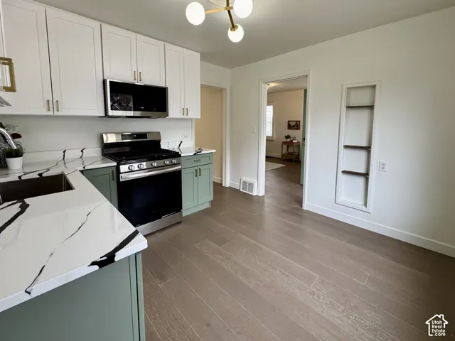 Newly remodeled kitchen with new soft close cabinetry, real wood floors and stunning quartz countertops. Small dining area