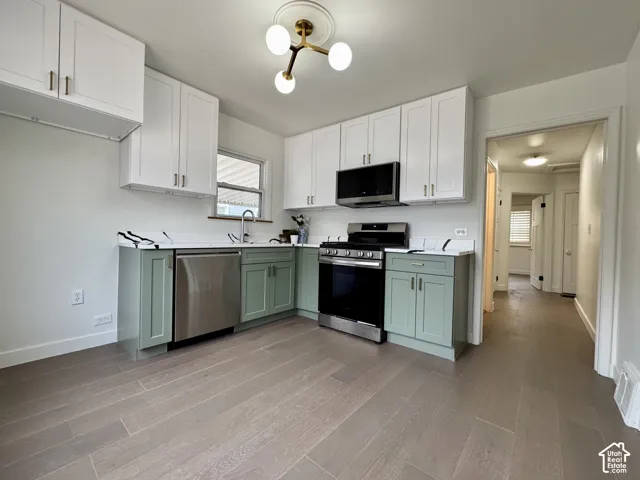 Newly remodeled kitchen with new soft close cabinetry, real wood floors and stunning quartz countertops. New stainless steel appliances